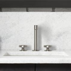 a bathroom sink with two faucets on the side and marble counter top above it