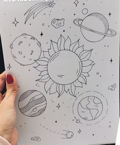 someone is holding up a coloring book with pictures of planets and sun on it in front of them