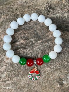 This bracelet is made with white, green and red glass beads and has an enamel Christmas wreath charm. Note: Colors may vary depending on your monitor Shipping Info: All orders are shipped from Canada and they are sent through Canada Post.  If you would like expedited shipping it will cost more and reach out and I can give pricing. Within Canada: Sent regular mail with no tracking.  It can take 5-10 business days to arrive. United States: Sent with tracking  International: Sent International Air White Holiday Jewelry For Festive Occasions, White Festive Jewelry For Christmas, White Christmas Festive Jewelry, White Christmas Jewelry For Holidays, White Christmas Jewelry For Festive Occasion, White Christmas Jewelry For Festive Season, White Beaded Christmas Jewelry, White Round Christmas Jewelry, White Charm Bracelet Gift