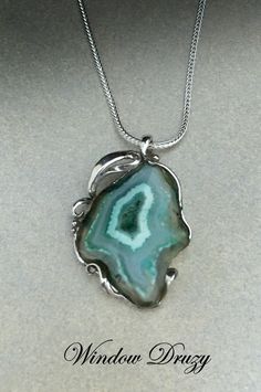 This is a one-of-a-kind piece given the unique stone and metal working. A druzy is cut from a geode to accommodate it for jewelry. This stone attracted me because of its layers of minerals, some opaque and others translucent, which make it a natural artwork in itself. The swirling bands of colors are echoed by the swirls of silver which secure the stone. The piece measures 1 3/8 inches by 7/8 inches wide handing upon an 18-inch silver chain. Greek Drama Masks, Natural Artwork, Drama Masks, Silver Rose Ring, Horse Earrings, Unicorn Necklace, Nature Artwork, Flower Bud, Silver Roses