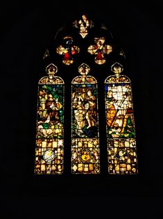 a very large stained glass window in a dark room