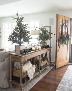 a living room filled with furniture and a christmas tree on top of a wooden table