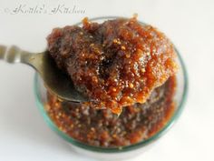 a spoon with some food in it on top of a glass bowl filled with sauce