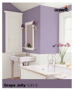 a bathroom with purple walls and white fixtures in the bathtub, sink and mirror