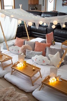 a living room filled with lots of furniture and pillows on top of a white bed