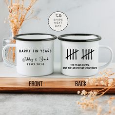 two personalized coffee mugs sitting on top of a wooden tray