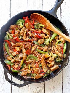 pork stir fry in a skillet with broccoli, peppers, and chicken