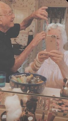 an older man taking a selfie with his cell phone in front of a mirror