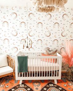 a baby's room with a crib, chair and rug