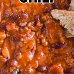 a bowl filled with chili and bread on top of a table