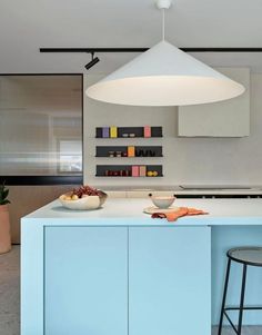 a kitchen with blue cabinets and an island in front of the countertop is filled with bowls of fruit