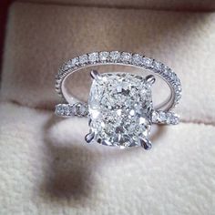 a cushion cut diamond ring with pave set shoulders