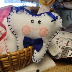 a tooth stuffed animal sitting in a basket next to some other items on a table