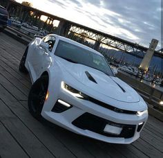 a white car parked on top of a wooden dock