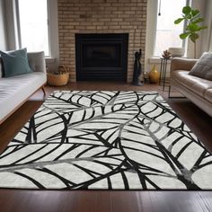 a living room filled with furniture and a large rug on top of a hard wood floor