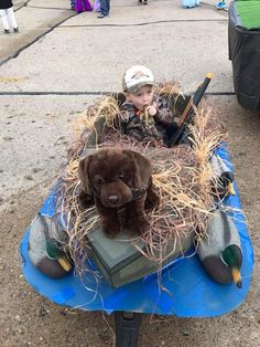 a baby sitting on top of a pile of hay with a stuffed animal in it