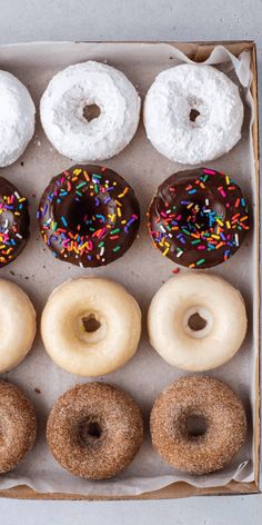 six different donuts in a box with sprinkles