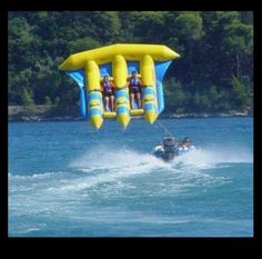 two people are in the air on a water sport boat while being pulled by a jet ski