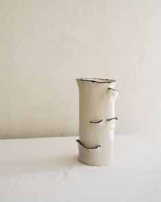 a white vase sitting on top of a table