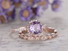 an engagement ring set with a pink sapphire surrounded by white and rose gold diamond accents