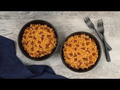 two black bowls filled with food next to silverware