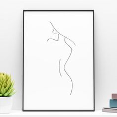 a black and white drawing of a woman's body on a shelf next to a potted plant