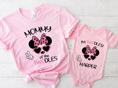 two pink onesuits with minnie and mickey mouse heads on them, one has the words mommy i'm two babies