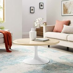 a living room with white couches and a coffee table in it's center