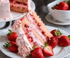 two slices of strawberry cake on plates with strawberries