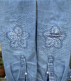 two pairs of blue jeans with holes in them