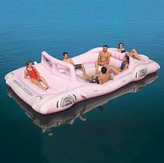 a group of people sitting on top of an inflatable raft floating on the water