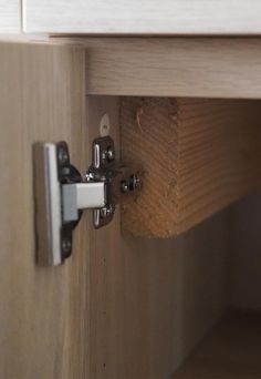 a close up of a door handle on a wooden cabinet