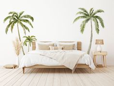 a bedroom with two palm trees on the wall and a bed in the foreground