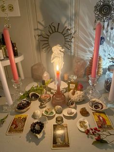 a table topped with lots of different types of candles and pictures on top of it