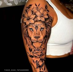 a woman's arm with a lion and flowers tattoo on her left arm, which is covered in black ink