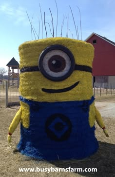 a yellow and blue stuffed animal sitting on top of a field