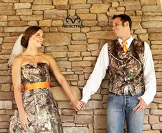 a man and woman holding hands in front of a stone wall with the words realtree on it