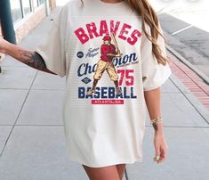 This Braves Atlanta Baseball Tee is perfect for any fan of the team. Made with high-quality materials, it offers comfort and durability. Show support in style with this officially licensed product. Sporty Tops For Baseball Season Fan Merchandise, Baseball Season Fan Apparel Tops With Sublimation Print, Baseball Season Fan Merchandise Graphic Print Tops, Throwback Baseball Fan Tops, Graphic Print Tops For Baseball Season Fan Merchandise, Game Outfit, Braves Baseball, Gaming Clothes, Baseball T Shirts