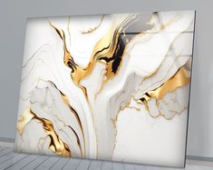 an abstract white and gold painting on the wall