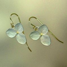 "This is my medium sized three petal hydrangea flower. Made of sterling silver with 18k yellow gold centers and 18k yellow gold earwires. The highly detailed flowers measure 5/8\" (14mm) and are finished with a whitened finish. The edges and fine veins are burnished for a little silvery sparkle. The earrings are finished with solid 18k yellow gold earwires on loops, to give these earrings a bit of movement. Each earring is signed P.Irla, 18k, .925, and copyright. Made to order in 7 to 10 busines Botanical Earrings, Jewelry Advice, Botanical Jewelry, Sterling Silver Flowers, Contemporary Jewellery, Contemporary Jewelry, Earrings Sterling Silver, Silver Flowers, Leaf Earrings