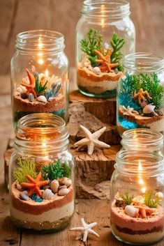 several jars filled with plants and rocks on top of a wooden table next to candles