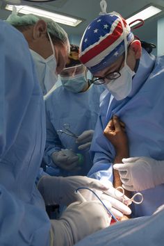 doctors performing surgery in an operating room with american flag on the cap and goggles