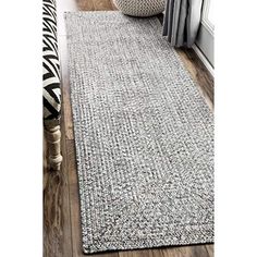 a gray rug on the floor next to a window