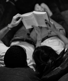 a man and woman laying down reading books