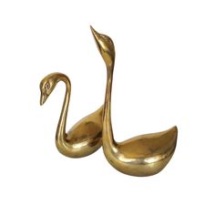 a gold colored metal swan figurine on a white background