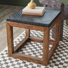 a table with a book on top of it in front of a chair and rug