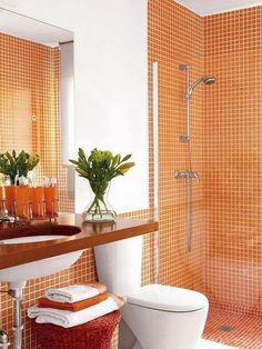 a bathroom with orange tiles on the walls