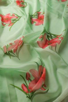 red flowers are on a green fabric