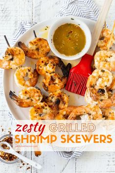 grilled shrimp skewers on a plate with dipping sauce