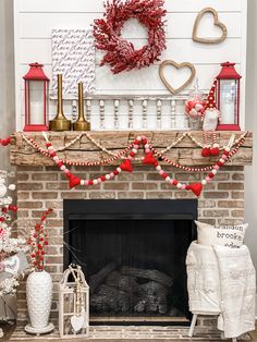 a fireplace decorated for valentine's day with red, white and gold decorations on the mantle